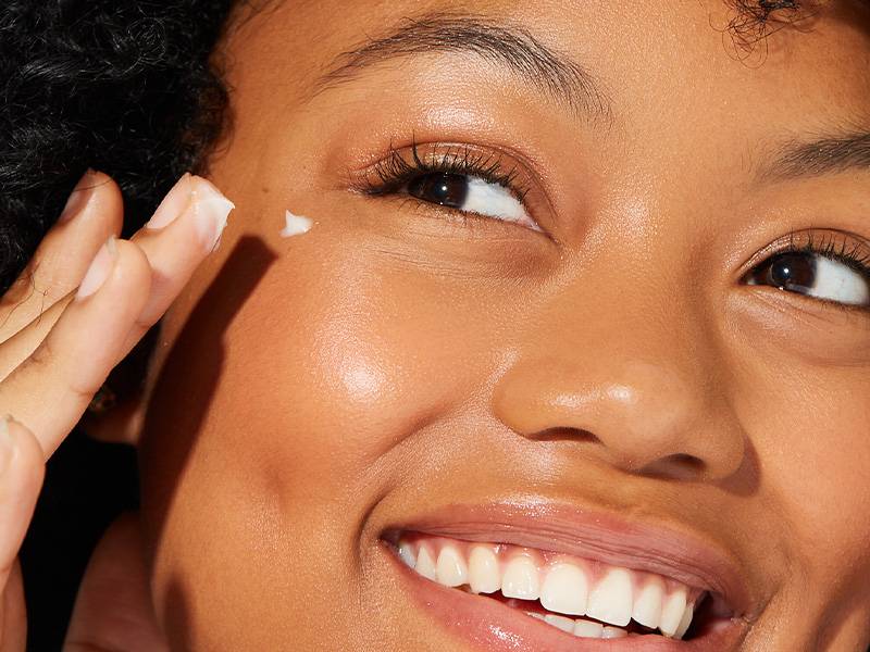 person applying eye cream