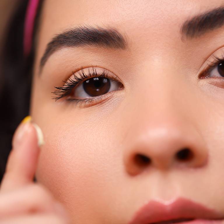 Person applying eye cream