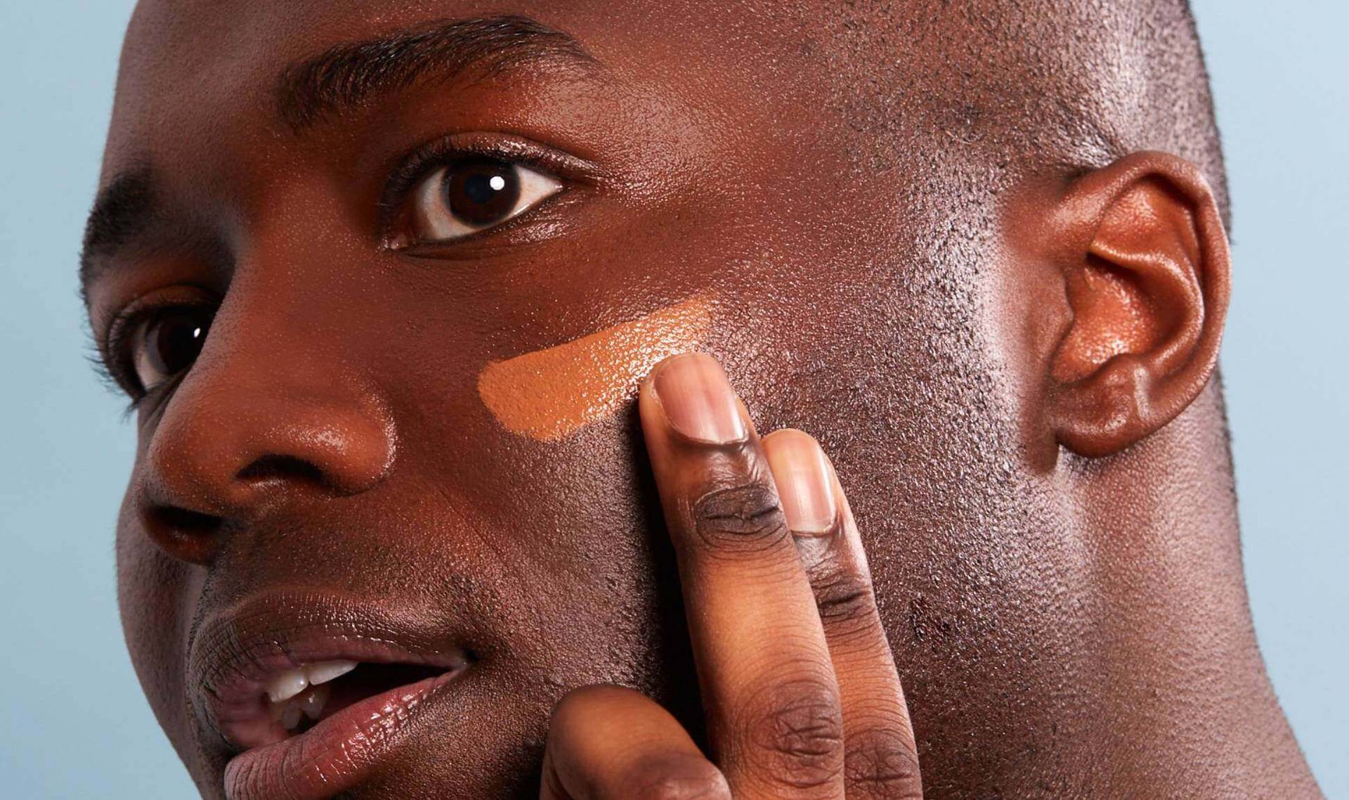 Male model applying foundation